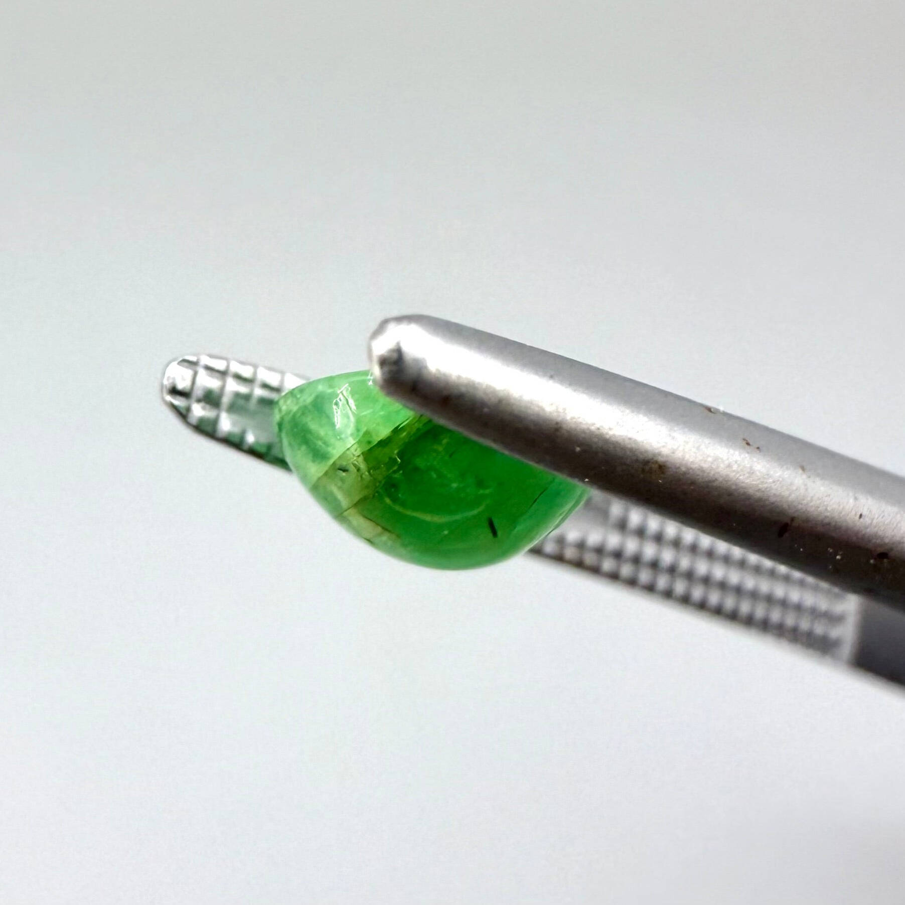 0.75 ct natural untreated emerald from Zambia, one side polished and the other cabochon-shaped.