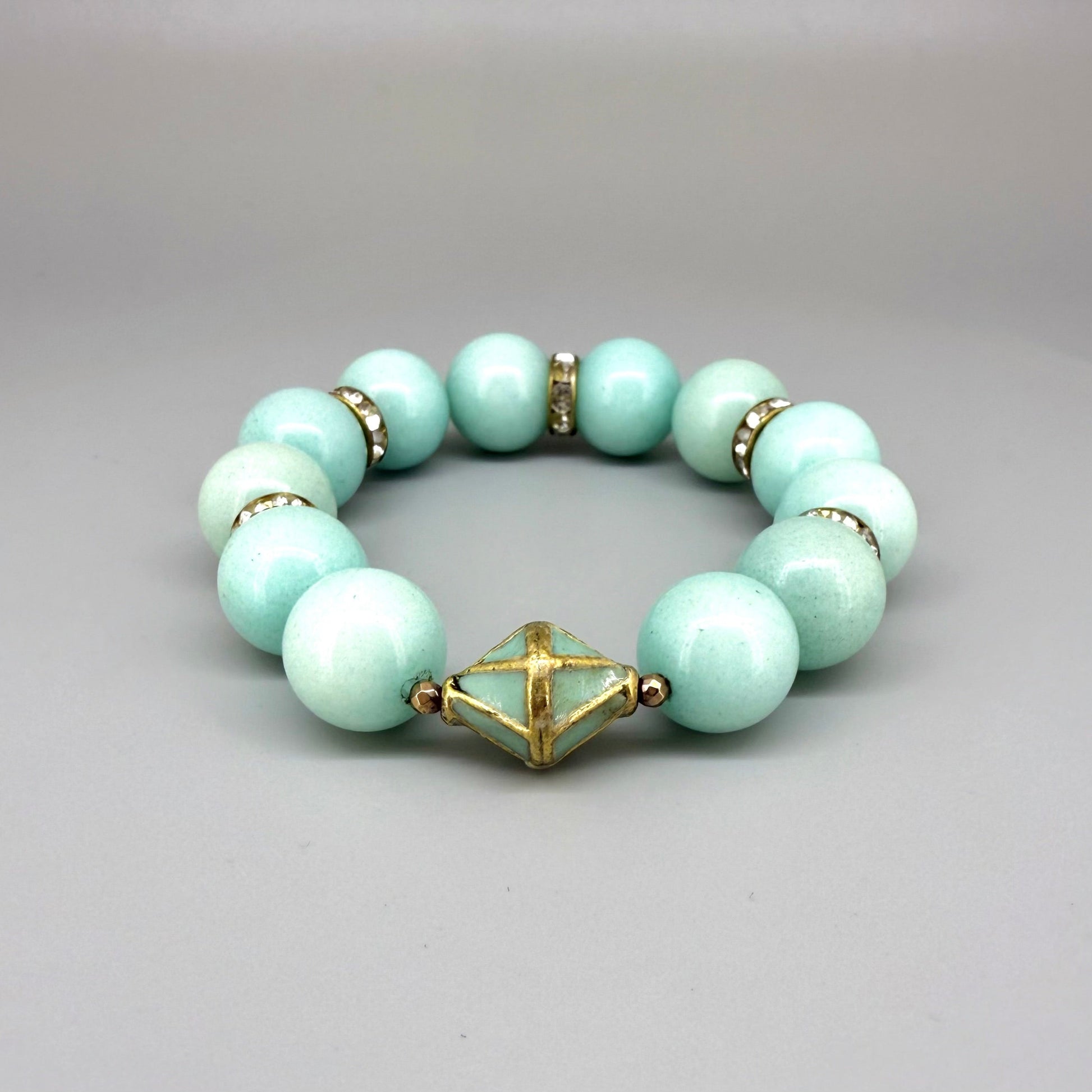 Larimar beaded bracelet, 18cm, aqua-blue gemstone beads with gold-toned spacers and decorative golden focal accent on elastic stretch band.