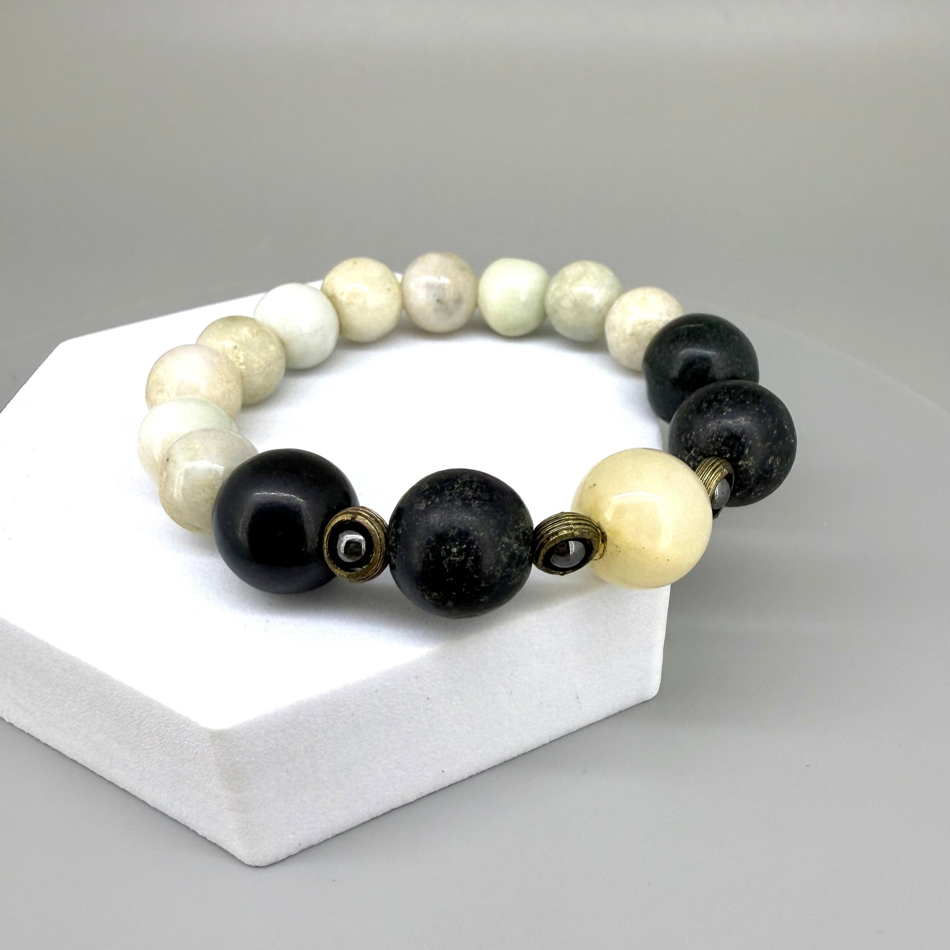 White jade, onyx, and hematite beaded bracelet, 18cm, natural white, black, and metallic grey gemstone beads with smaller hematite accents on elastic stretch band.