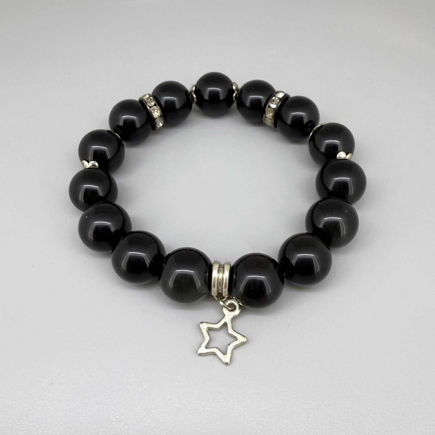 Obsidian beaded bracelet, 18cm, natural black gemstone beads with silver-toned star charm on elastic stretch band.