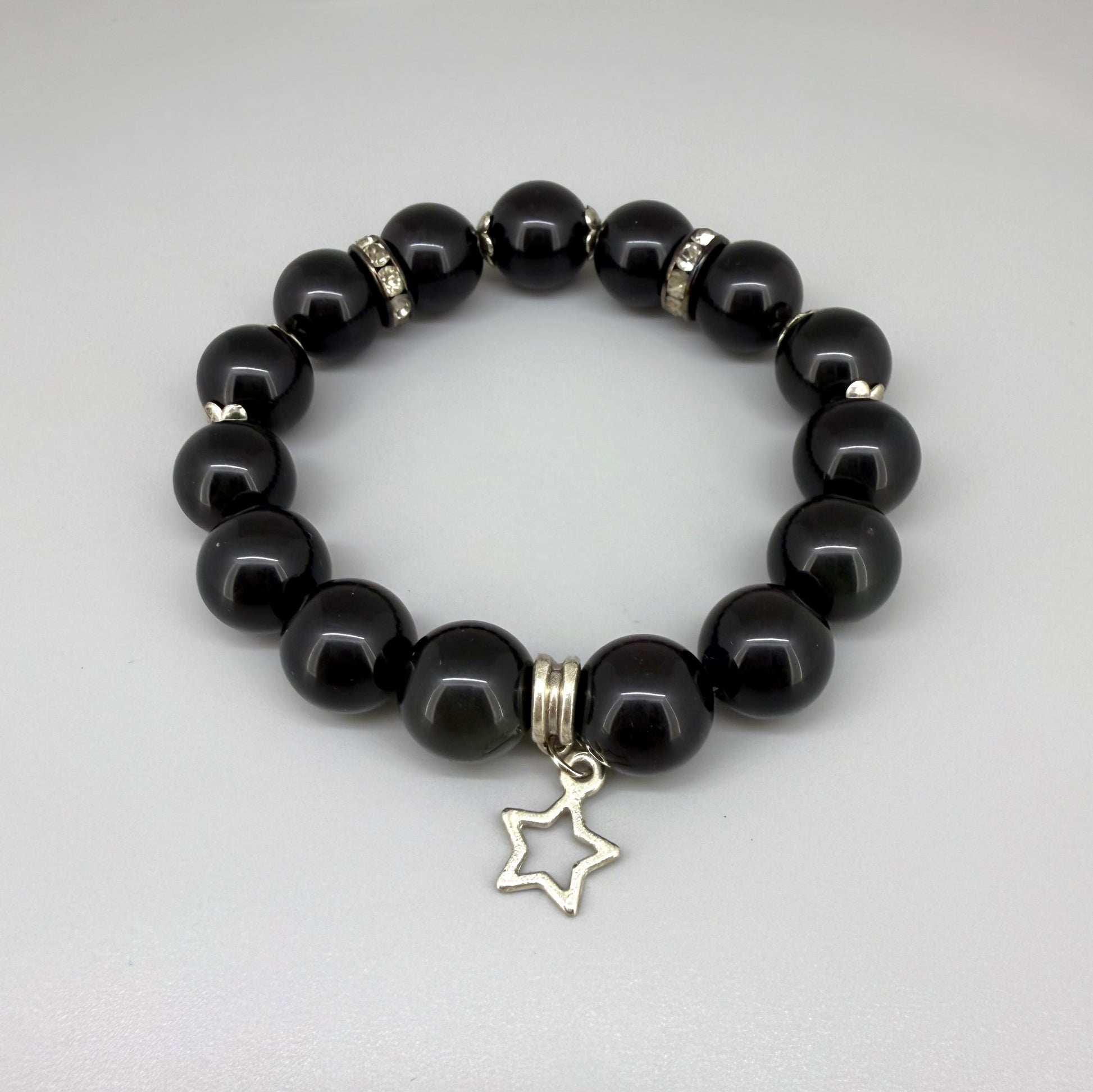 Obsidian beaded bracelet, 18cm, natural black gemstone beads with silver-toned star charm on elastic stretch band.