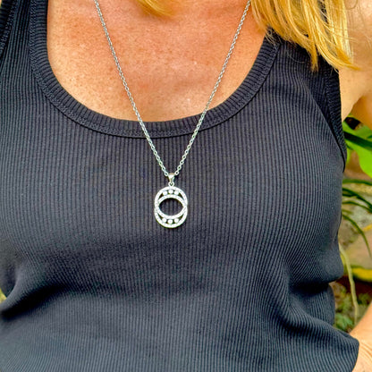 Handcrafted round pendant with cubic zirconia set in white-gold-plated sterling silver.