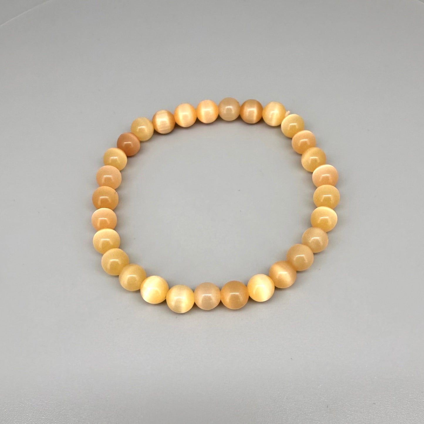 Cat’s Eye beaded bracelet, peach-orange gemstone beads with shimmering light effect on elastic stretch band.