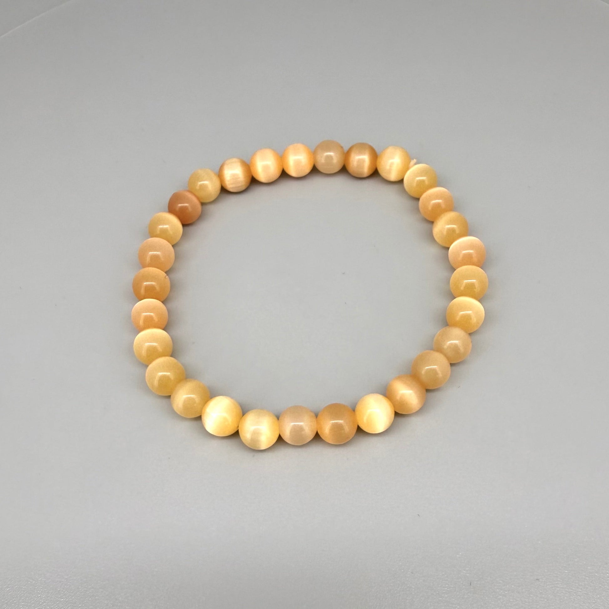 Cat’s Eye beaded bracelet, peach-orange gemstone beads with shimmering light effect on elastic stretch band.