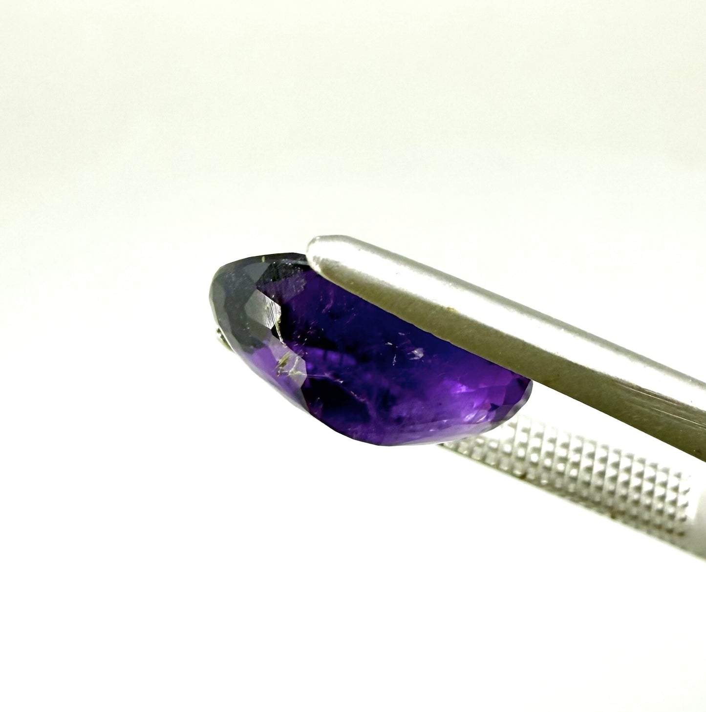 Round purple gemstone on a white background
