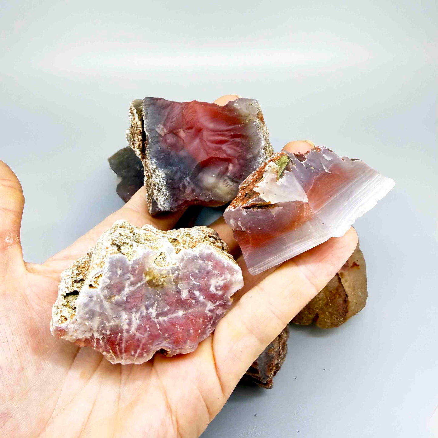 Mixed chalcedony rough stones with pink, orange-red and grey banded patterns, natural quartz lot.