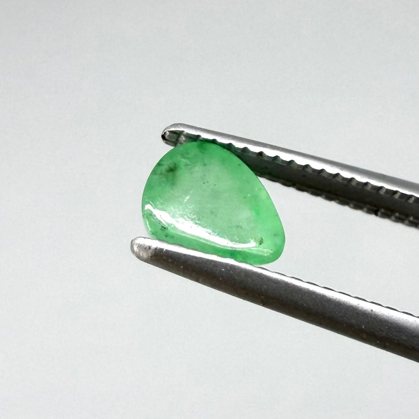 0.51 ct natural untreated emerald from Zambia, one side polished and the other cabochon-shaped.