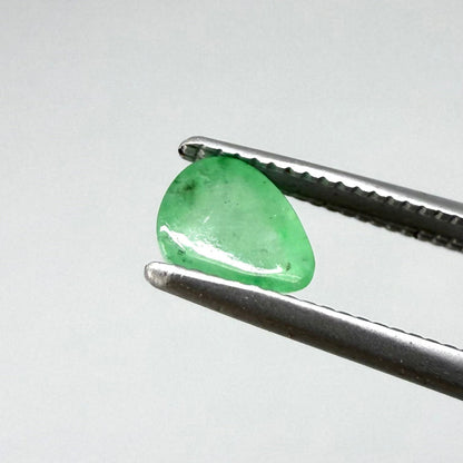 0.51 ct natural untreated emerald from Zambia, one side polished and the other cabochon-shaped.