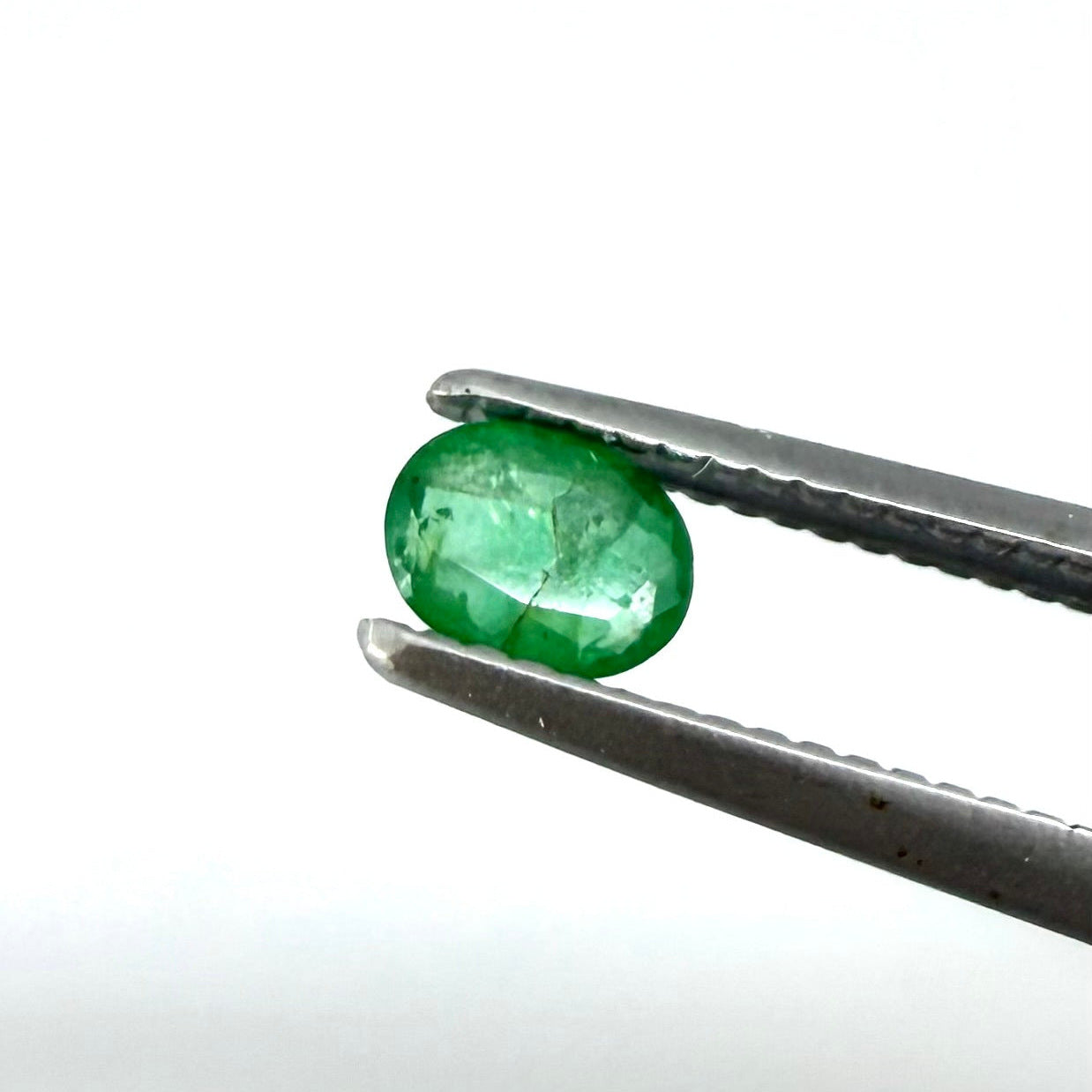 0.18 ct natural untreated Zambian emerald, oval faceted with bright bluish-green color.