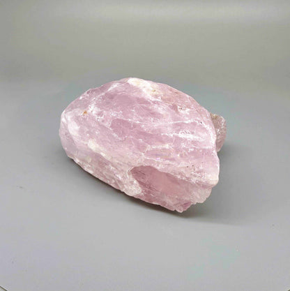 Natural rose quartz rough stone, translucent untreated pink quartz in raw form photographed in natural light