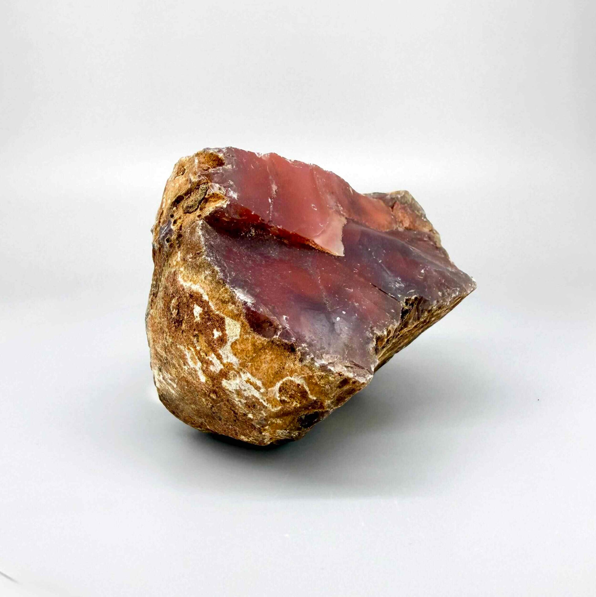 Natural red chalcedony rough (quartz) with warm orange to deep red tones, uncut gemstone.