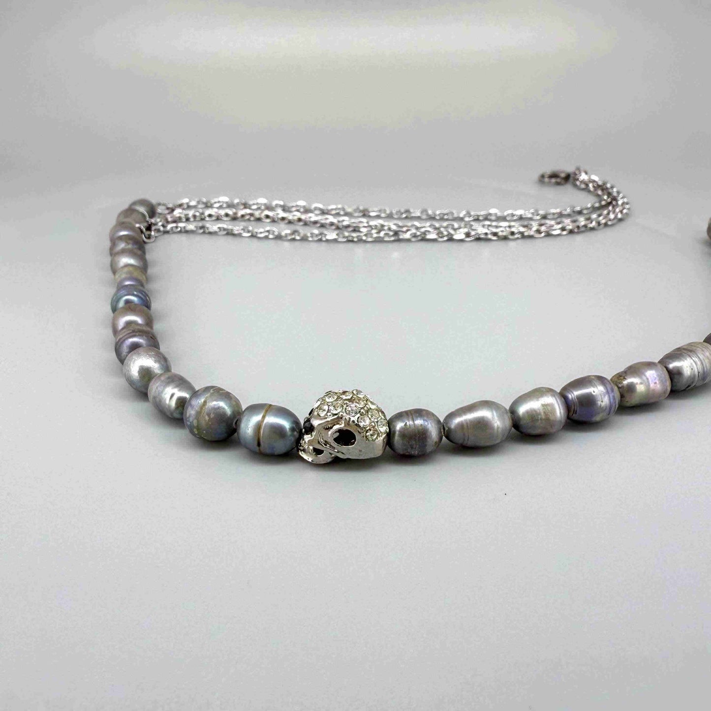 Cultured pearl necklace, 43 cm / 17 in long, with soft grey pearls and a central silver accent bead.