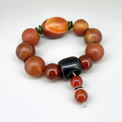 Carnelian and agate beaded bracelet, 20cm, red-orange gemstone beads with large black square bead on elastic stretch band.
