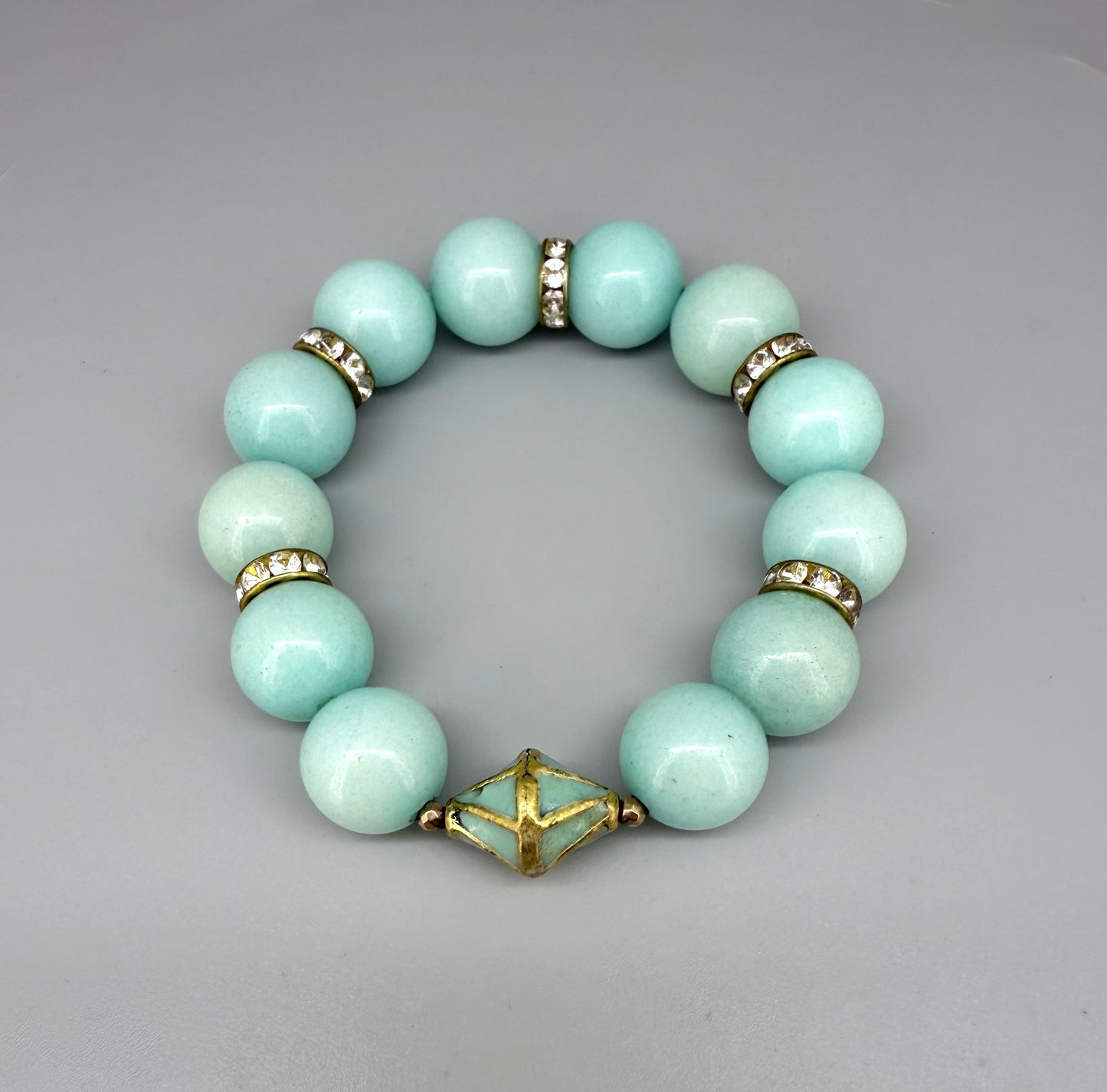 Larimar beaded bracelet, 18cm, aqua-blue gemstone beads with gold-toned spacers and decorative golden focal accent on elastic stretch band.