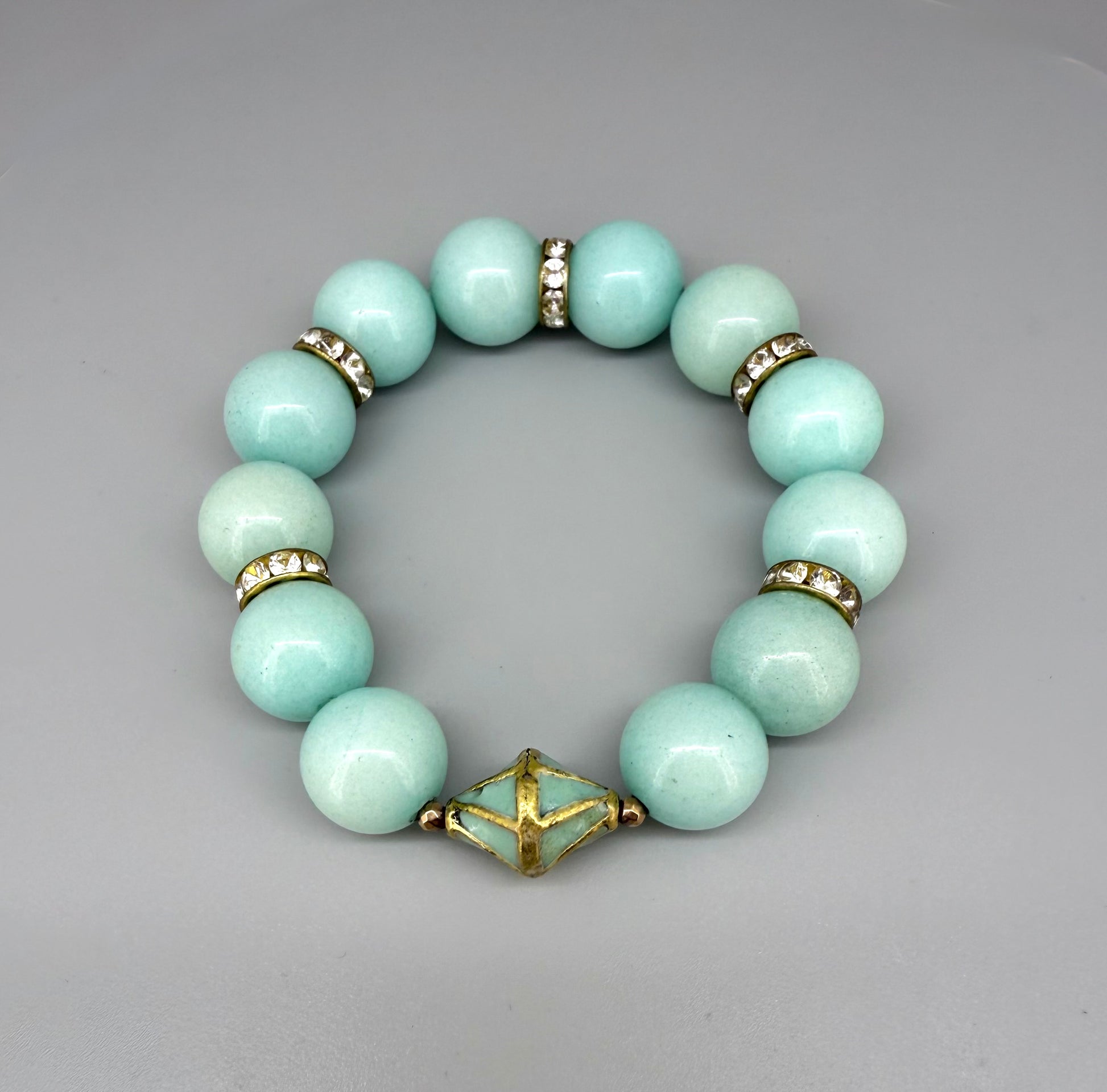 Larimar beaded bracelet, 18cm, aqua-blue gemstone beads with gold-toned spacers and decorative golden focal accent on elastic stretch band.