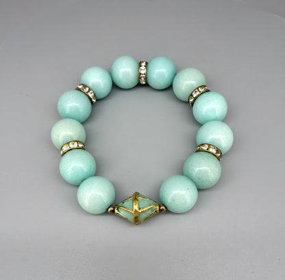 Larimar beaded bracelet, 18cm, aqua-blue gemstone beads with gold-toned spacers and decorative golden focal accent on elastic stretch band.