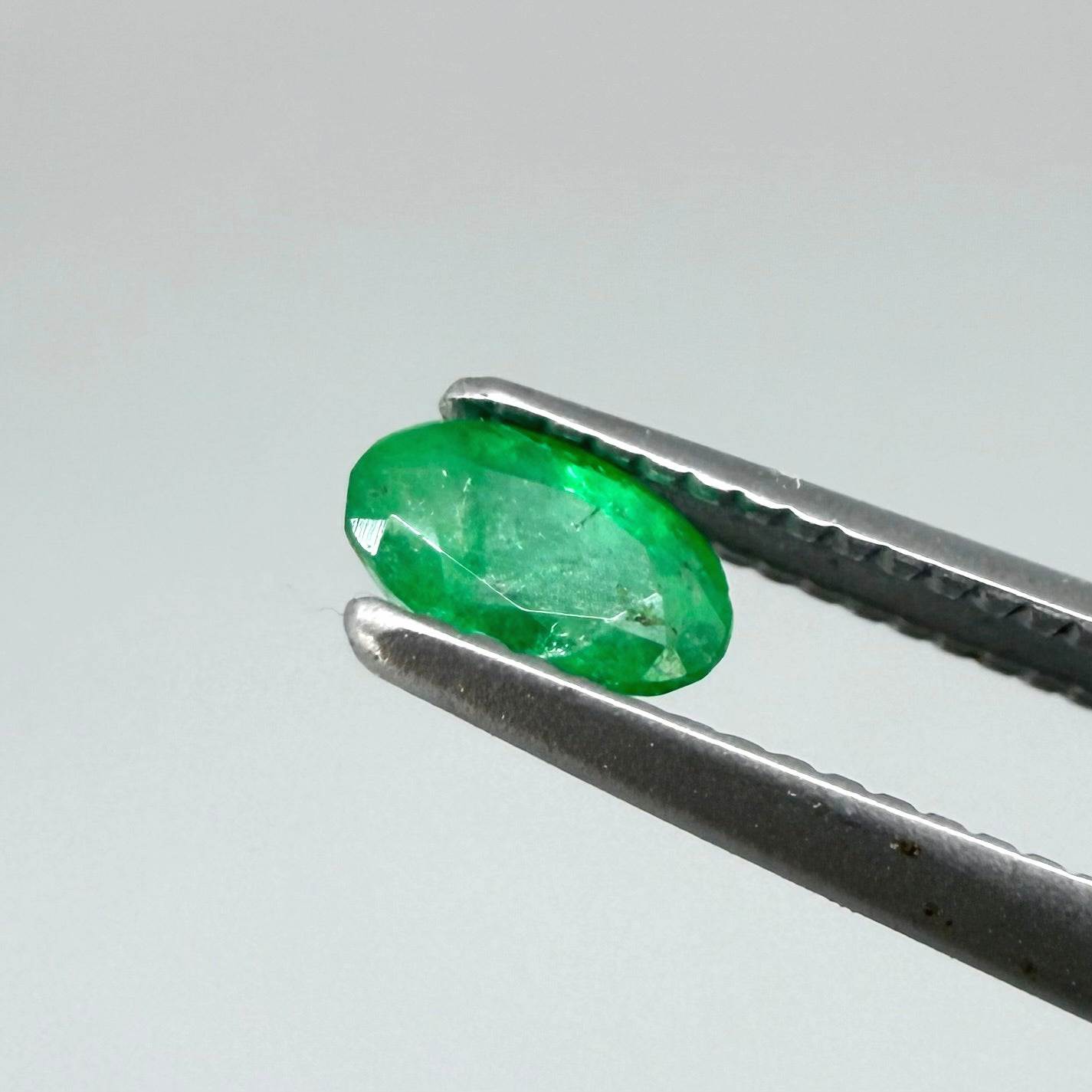 0.18 ct natural untreated Zambian emerald, oval faceted with vivid bluish-green color.