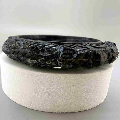 Carved dark jade-style bangle with sculptural relief details and polished surface, 19 cm inner circumference