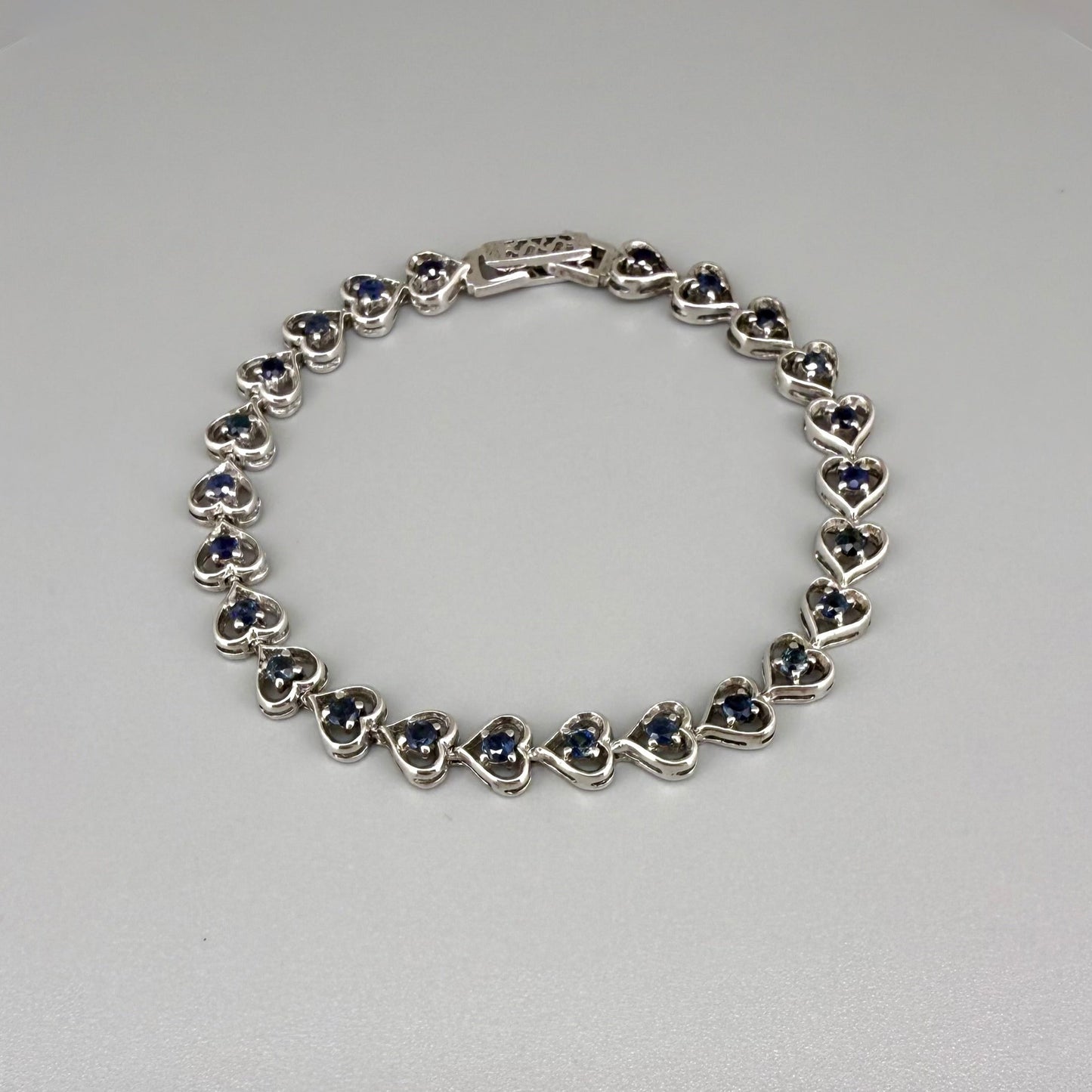 Sapphire bracelet in sterling silver with white gold plating, elegant design on neutral background