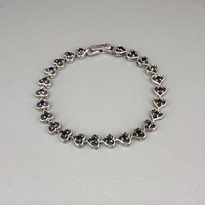 Sapphire bracelet in sterling silver with white gold plating, elegant design on neutral background