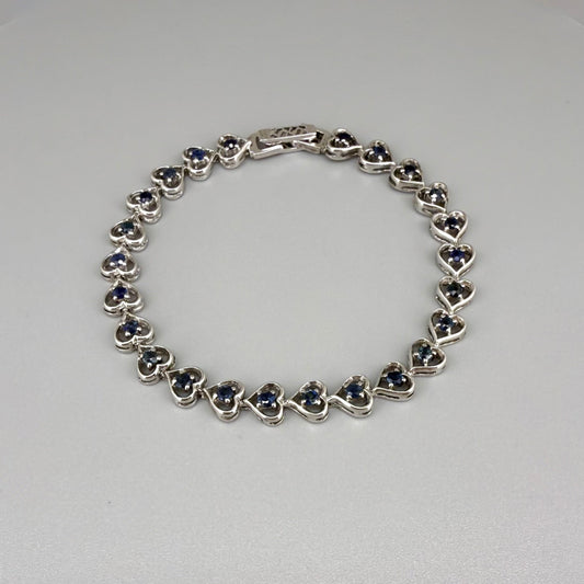 Sapphire bracelet in sterling silver with white gold plating, elegant design on neutral background