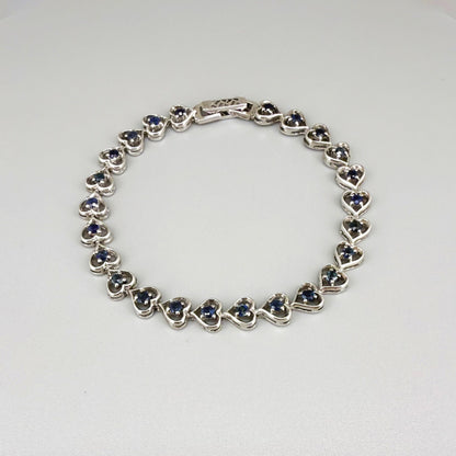 Sapphire bracelet in sterling silver with white gold plating, elegant design on neutral background