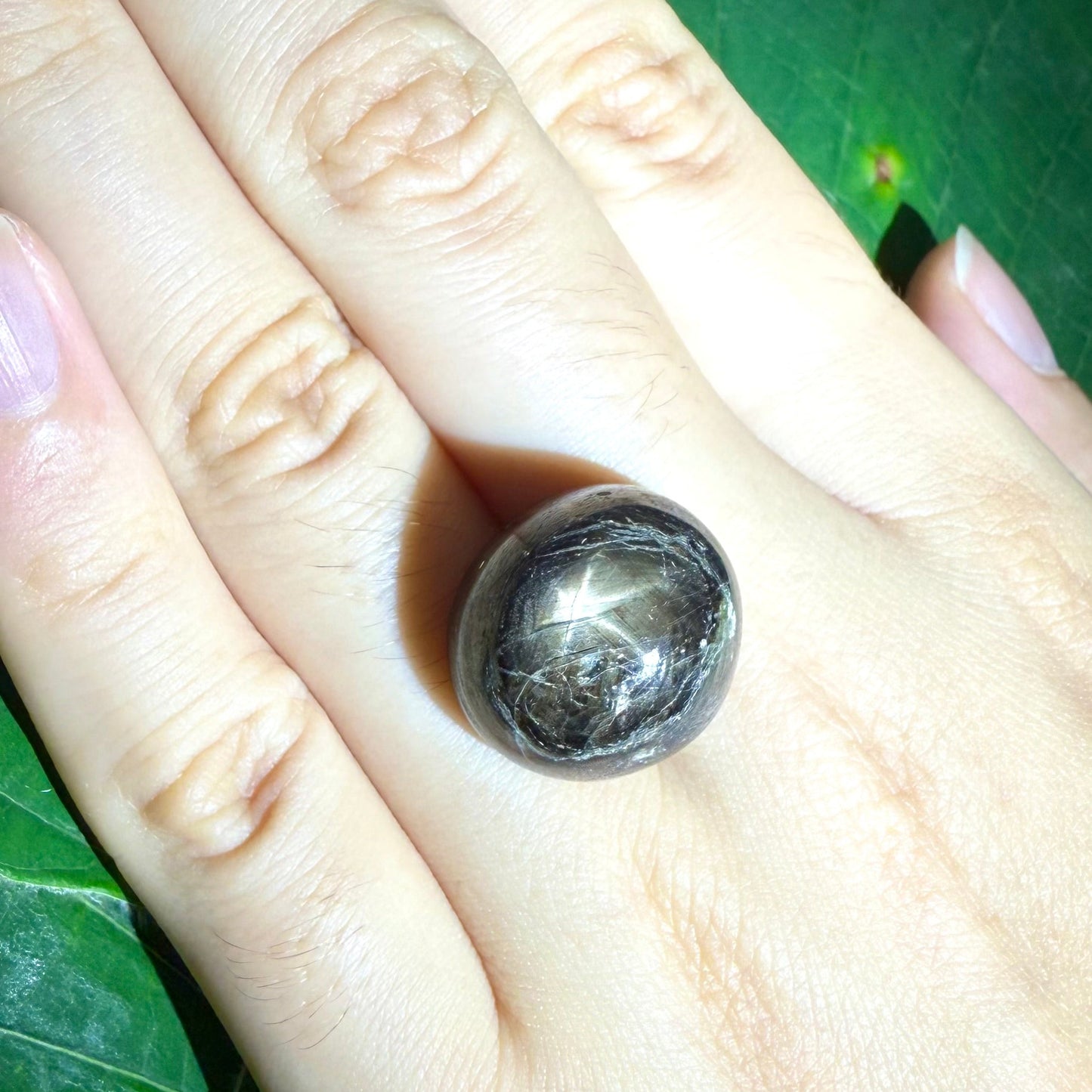Golden-brown star sapphire cabochon, natural gemstone with visible asterism