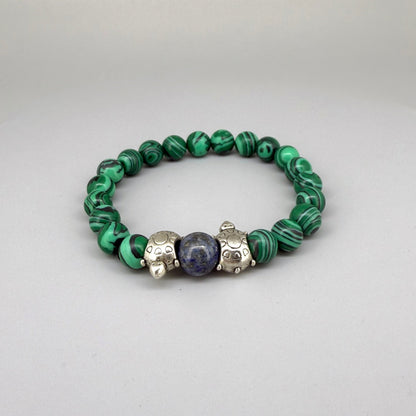 Malachite beaded bracelet, 18cm, green gemstone beads with central blue bead framed by two metal turtle accents on elastic stretch band.