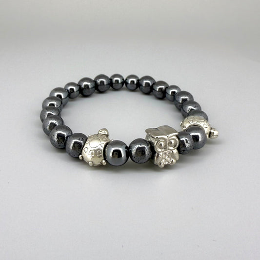Hematite beaded bracelet, 18cm, metallic dark grey gemstone beads with two turtle accents and one owl charm on elastic stretch band.