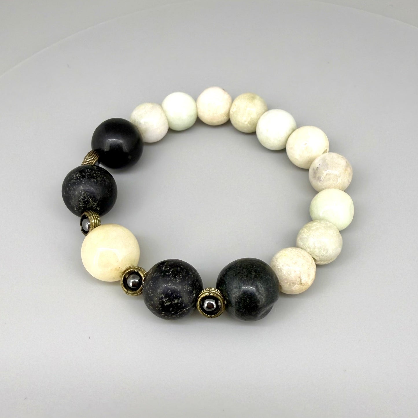 White jade, onyx, and hematite beaded bracelet, 18cm, natural white, black, and metallic grey gemstone beads with smaller hematite accents on elastic stretch band.