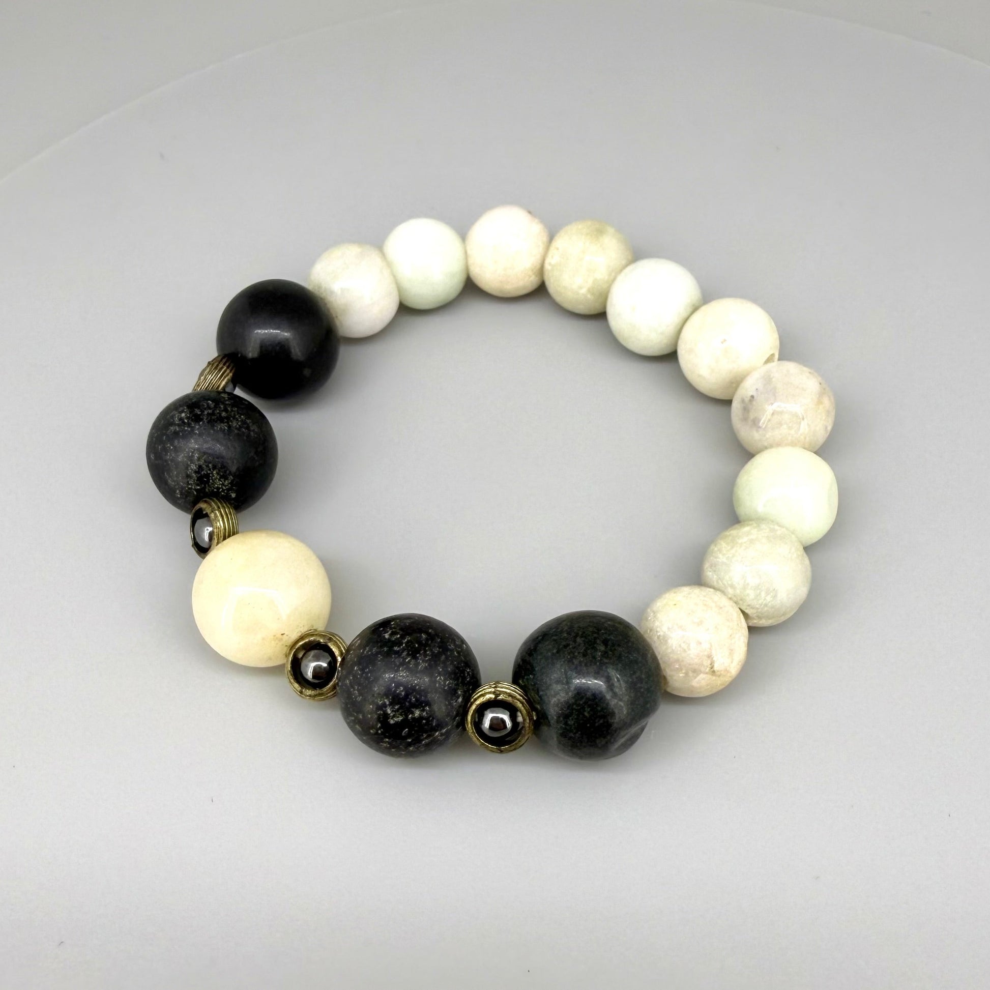 White jade, onyx, and hematite beaded bracelet, 18cm, natural white, black, and metallic grey gemstone beads with smaller hematite accents on elastic stretch band.