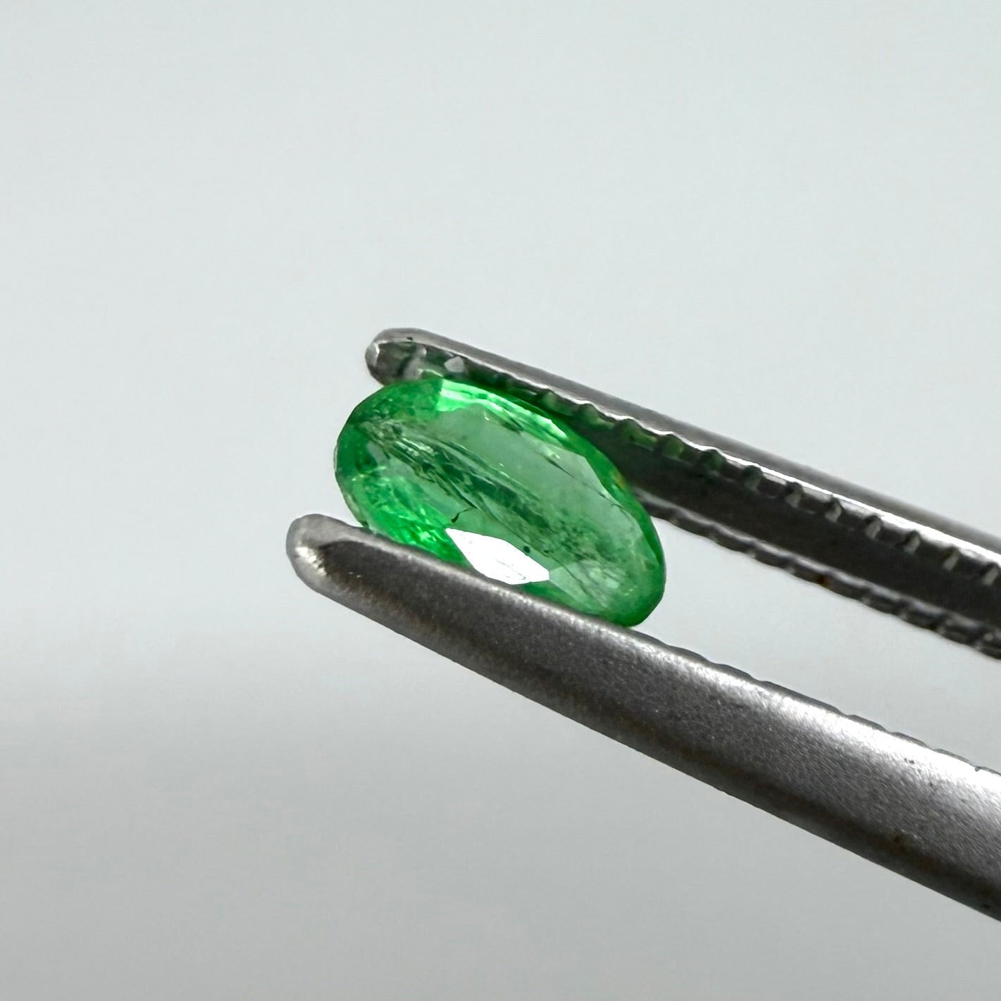 0.22 ct natural untreated Zambian emerald, oval faceted with vivid bluish-green color.