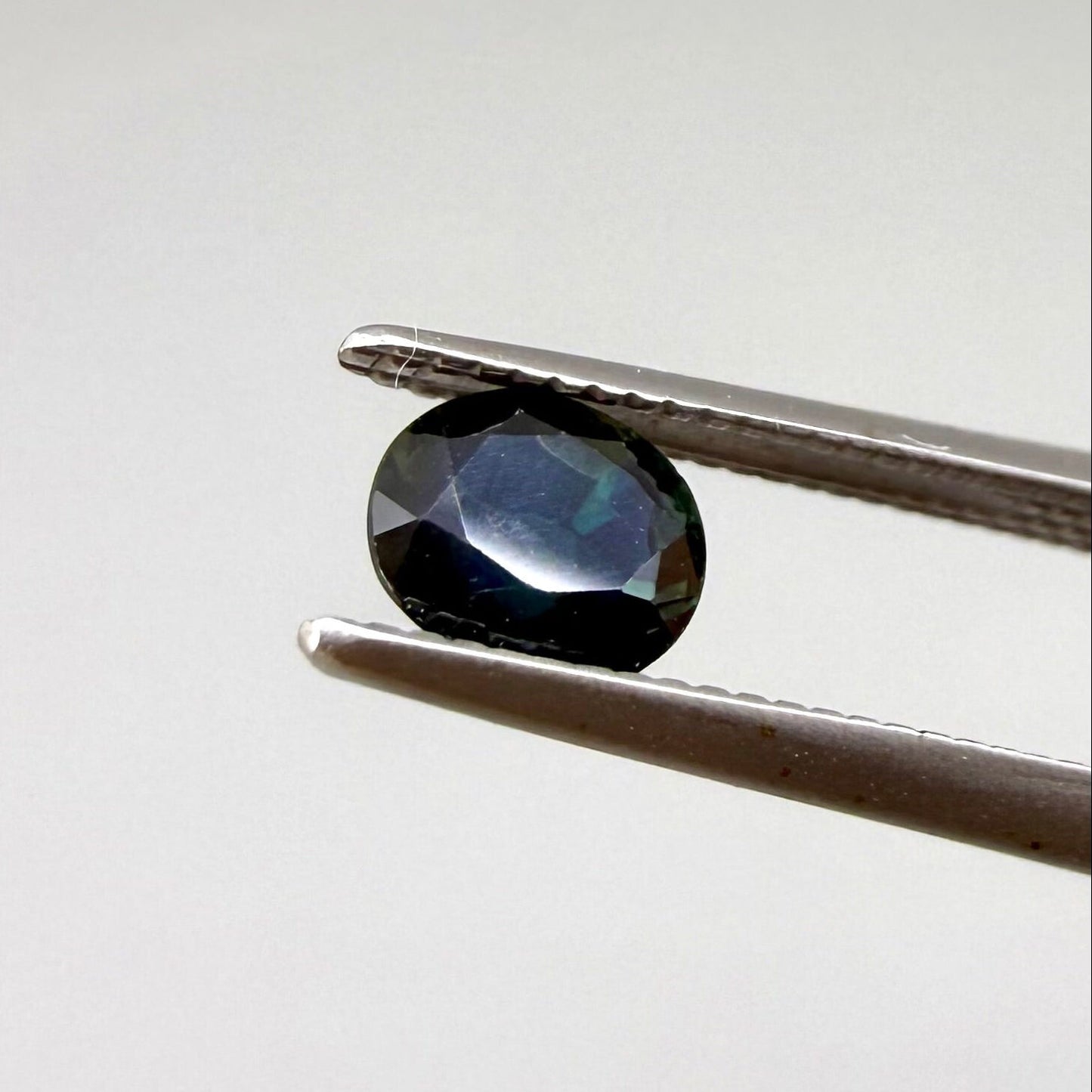 0.67 ct natural blue-green sapphire from Bangkaja, faceted cut.