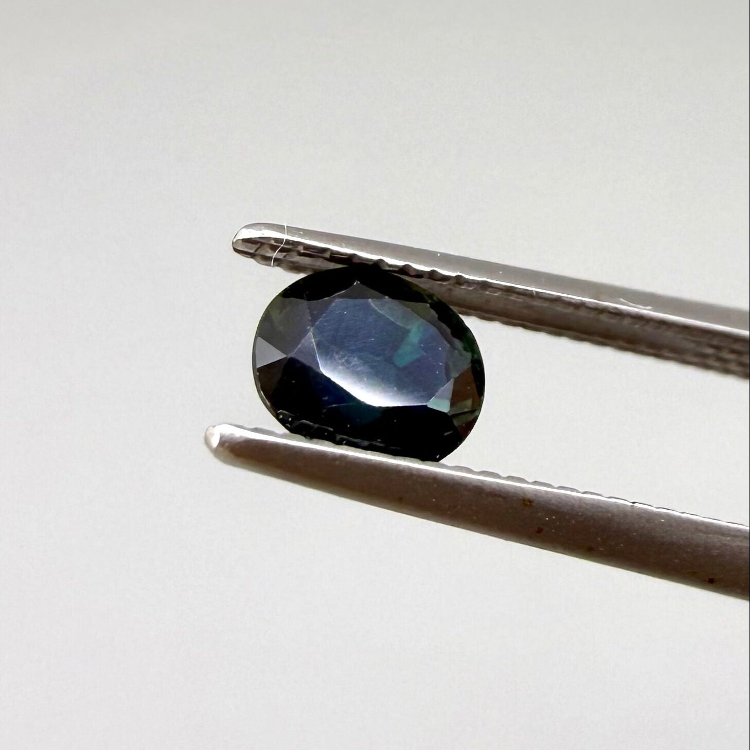 0.67 ct natural blue-green sapphire from Bangkaja, faceted cut.