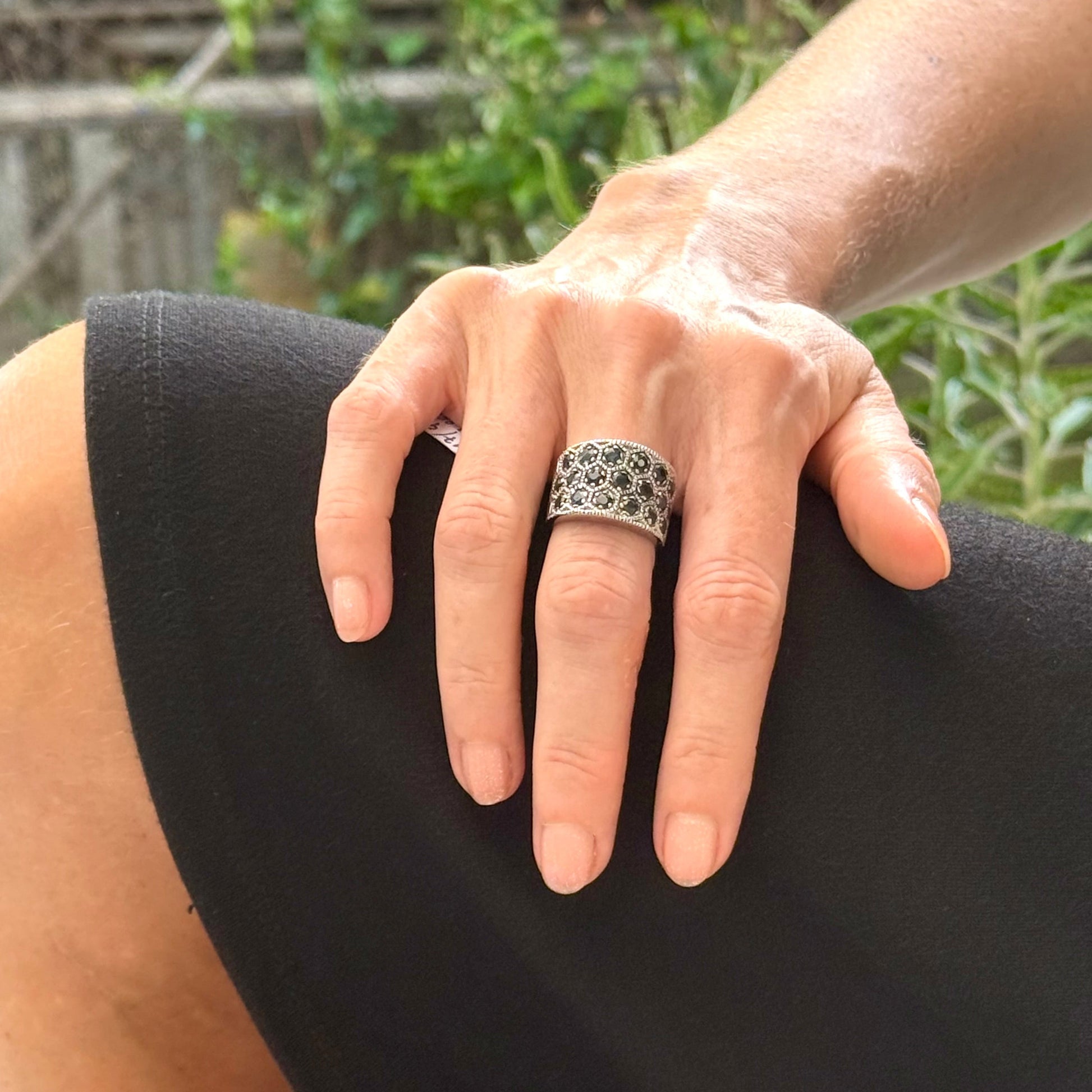Wide band blue sapphire ring in white gold plated sterling silver featuring faceted deep blue sapphires for an elegant, timeless look.