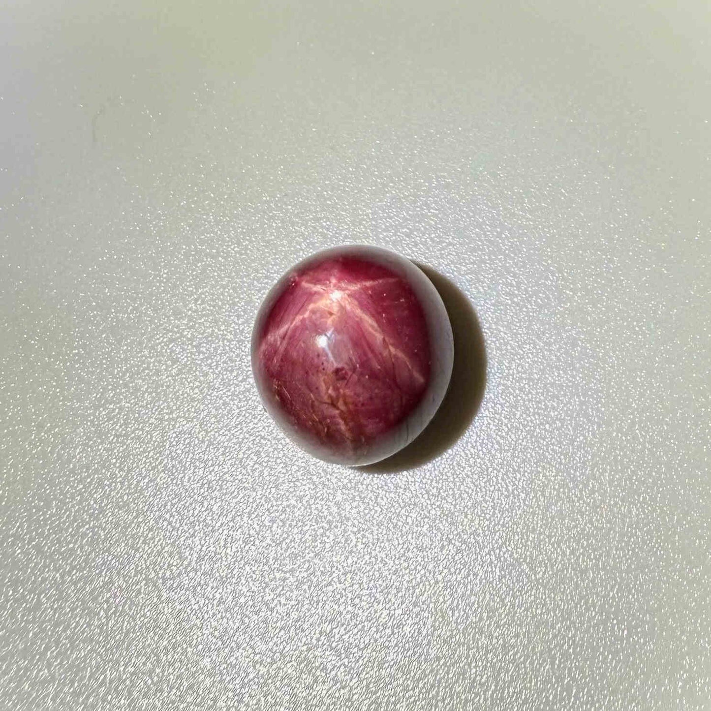 20.1 ct natural Pink-Red Star Ruby cabochon from Mozambique with soft star effect and polished dome.