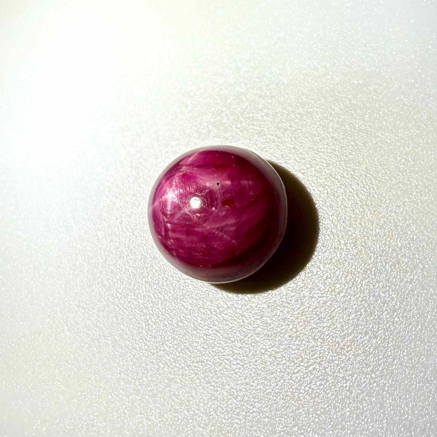 19.1 ct natural Star Ruby cabochon with visible star effect, deep red color and polished dome shape."