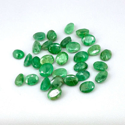 5.5 ct natural untreated Zambian emerald lot, faceted oval stones with vivid bluish-green color.