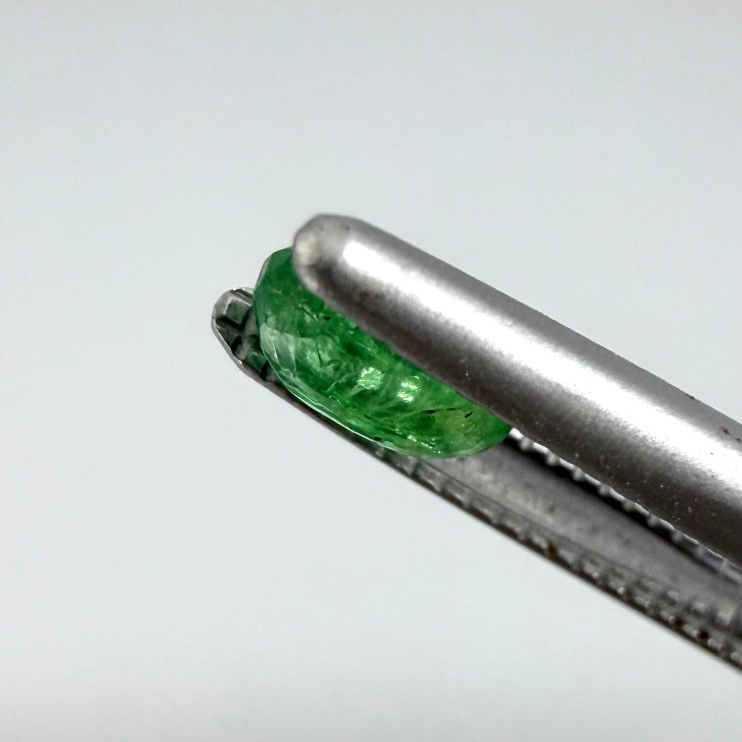 0.22 ct natural untreated Zambian emerald, oval faceted with vivid bluish-green color.