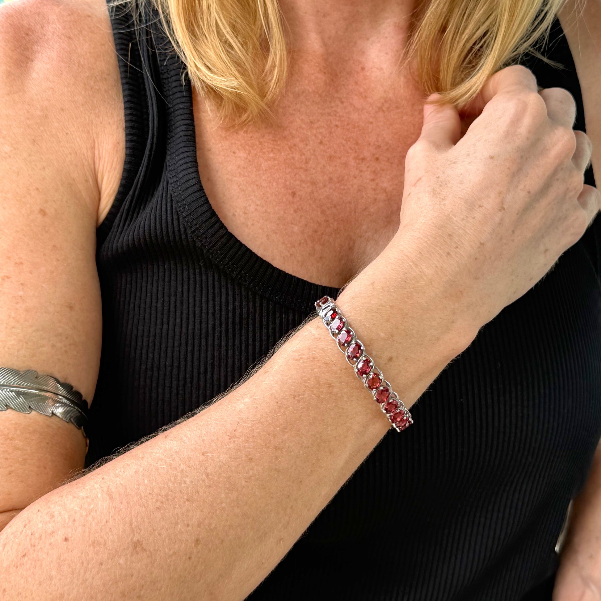 Rhodolite garnet bangle in sterling silver with white gold plating worn on wrist