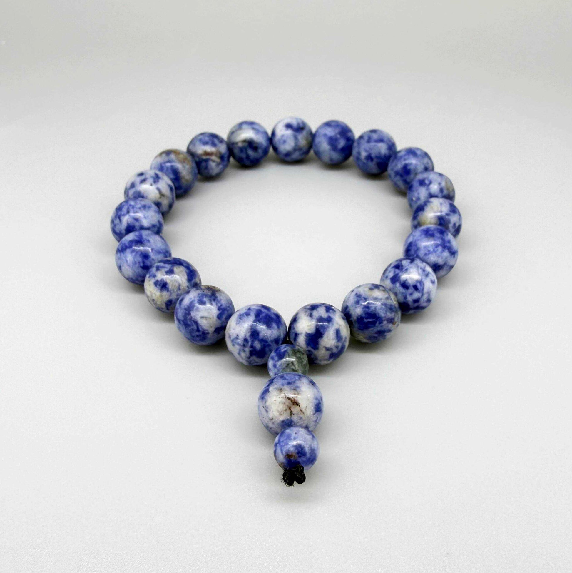 Blue Jasper mala bracelet with marbled blue and white natural gemstone beads and decorative charm detail.