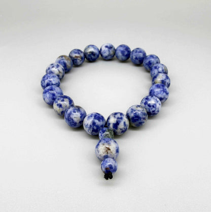 Blue Jasper mala bracelet with marbled blue and white natural gemstone beads and decorative charm detail.