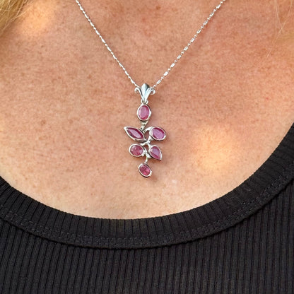 Handcrafted white-gold-plated silver pendant with 4.44 ct natural rubies in a floral design.