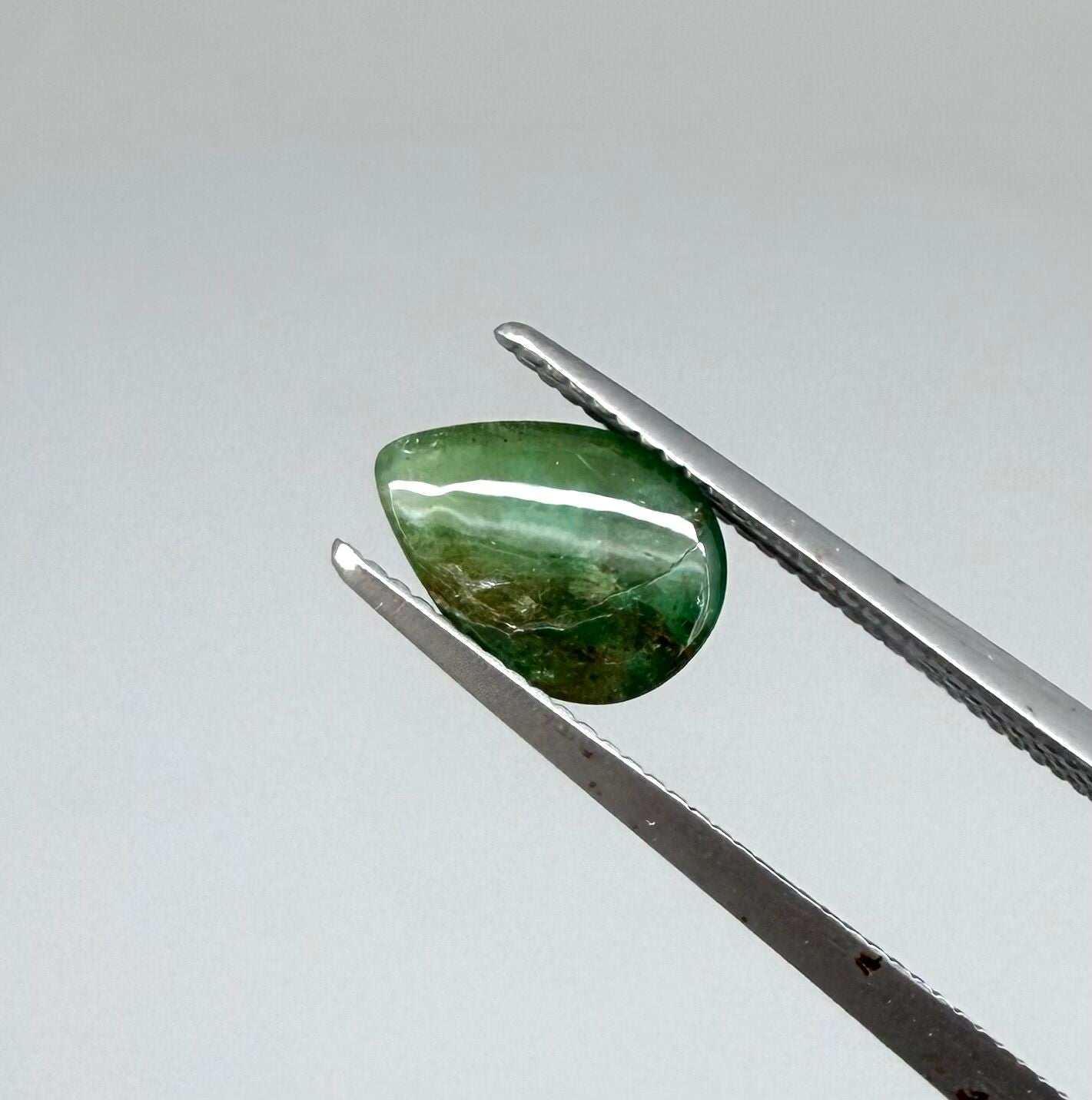 0.82 ct natural untreated emerald from Zambia, one side polished and the other cabochon-shaped.