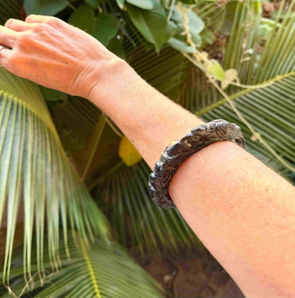 Carved dark jade-style bangle with sculptural relief details and polished surface, 19 cm inner circumference