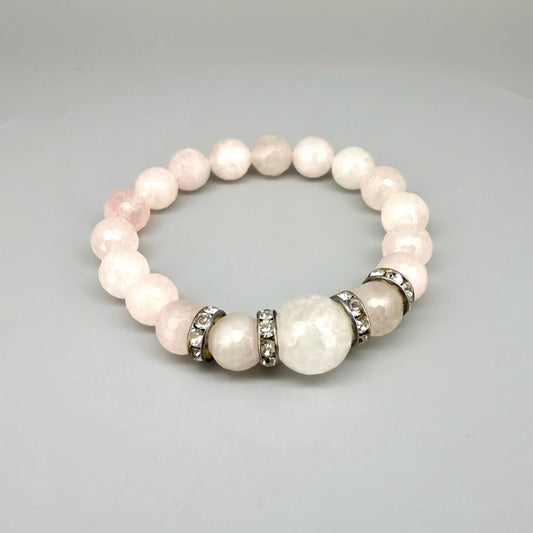 Rose quartz beaded bracelet, 18cm, light pink gemstone beads with larger central bead and decorative metal accents on elastic stretch band.