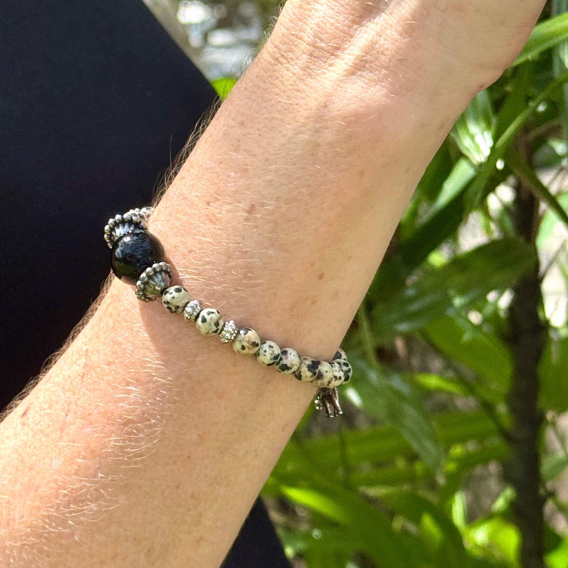Dalmatian jasper beaded bracelet, 17cm, cream with black speckled gemstone beads and one large black accent bead on elastic stretch band.