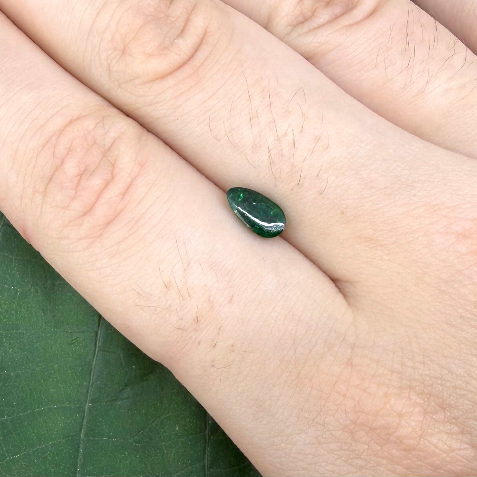 0.82 ct natural untreated emerald from Zambia, one side polished and the other cabochon-shaped.
