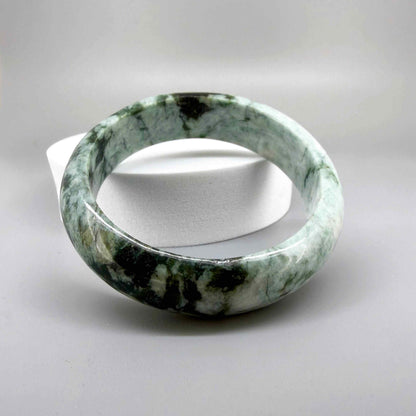 Polished jade bangle in soft green hues with smooth surface and natural variations, 20 cm inner circumference