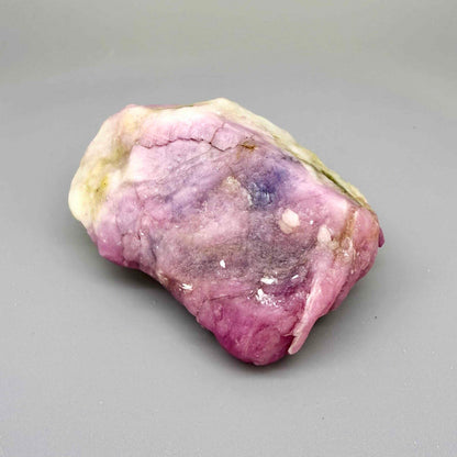Natural ruby in creamy-white matrix, pink to purplish-pink rough corundum partially encased in host rock.